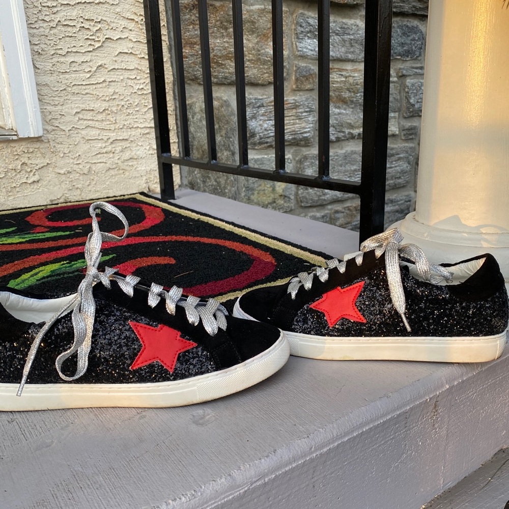 Sparkly black sneakers with a red star